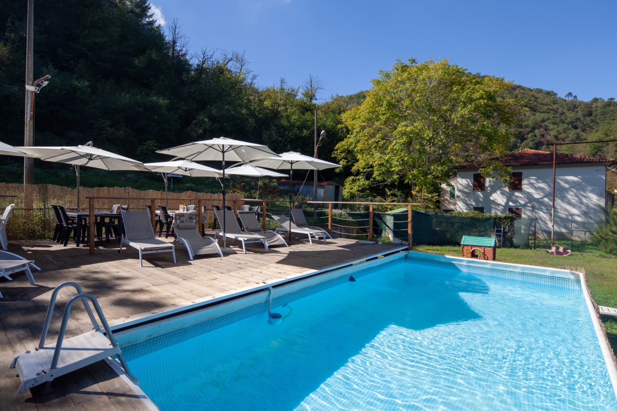 La nostra piscina stagionale e giardino, per relax e cene a bordo piscina in estate. Il tempo del vento B&b In Lunigiana