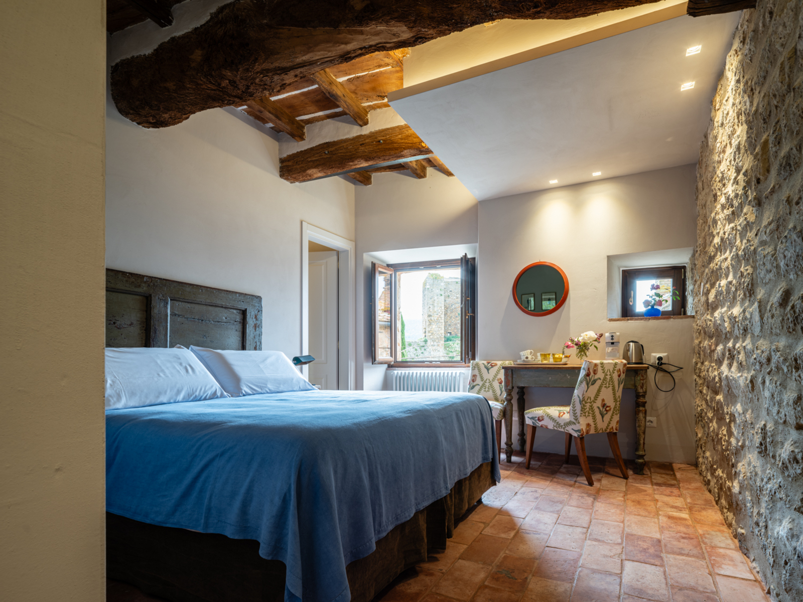 Un letto matrimoniale con coperte azzurre del Rooms and wine Bed and breakfast a Monteriggioni